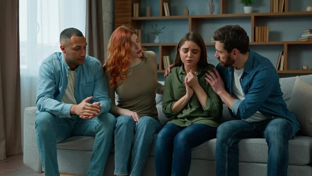Desperate sad woman cry complain life problem diverse women and men colleagues buddies support stressed girl multiracial team sit on psychological therapy group meeting at home give help calm friend