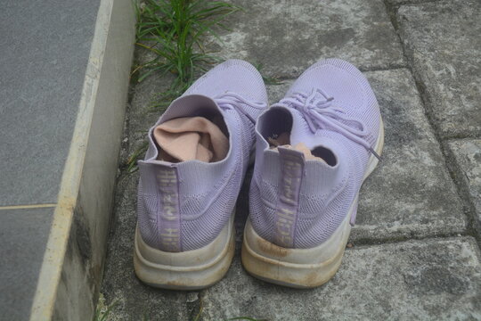 April 2023, a purple shoe with a sock inside is lying on the ground.