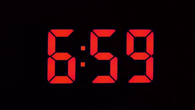 Red seven-segment numbers, LED clock close-up, shows 7-00 am, the concept of the beginning of the working day.
