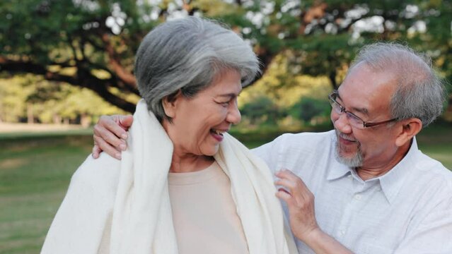 Asian senior man embrace with blanket to wife in the garden, Love and care concept