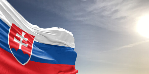 Slovakia national flag cloth fabric waving on beautiful grey sky Background.