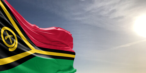 Vanuatu national flag cloth fabric waving on beautiful grey sky Background.