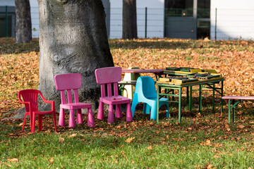 Bunte Stühle für Kinder in einem herbstlichen Garten