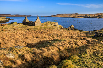 A ruined old croft house sits on the shore overlooking Loch Barraglom on the Isle of Lewis.