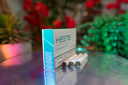 QOS, a Tobacco heating system  by Philip Morris - tobacco product technologies - hybrid heets cigarette on a wooden background