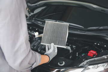 Auto mechanic checking, cleaning and replacing car air filter. Concept of car care service maintenance.