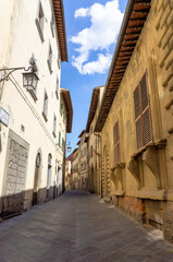 Fototapeta na wymiar Street in historical center of Arezzo with facade of medieval buildings. Tuscany, Italy