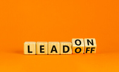 Lead on or off symbol. Businessman turns wooden cubes and changes word Lead off to Lead on. Beautiful orange table orange background. Business and lead on or off concept. Copy space.