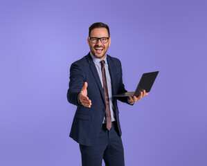 Male cheerful CEO with laptop extending his arm for handshake after successful deal isolated...