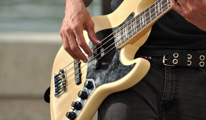 Person playing bass guitar outdoors