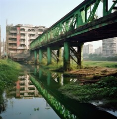 Fototapeta na wymiar an old train line with green tracks is seen over water and buildings Generative Ai