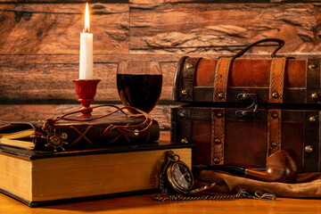book and wine by candle light with pipe and gold watch