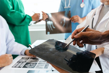 A team of young doctors discuss CT scan results in the clinic. Show patient results at the modern...