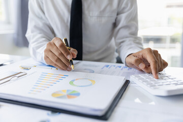 Modern male businessman or marketing data analyst working with laptop and graph data in office.