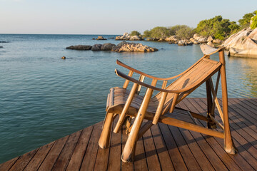 Fototapeta na wymiar Wooden armchair at resort patio by sea, Ko Man Klang, Rayon