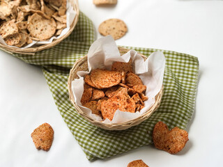 Basreng, Indonesian traditional chip made from fried meatball with chilli powder and lime leaves for seasoning served on wooden plate. Spicy Indonesian chip. Isolated white background.