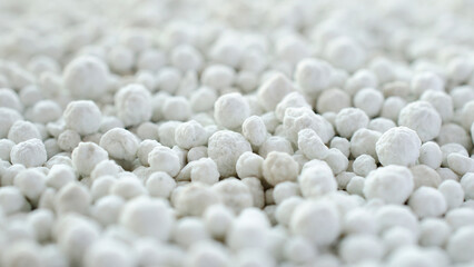 Ammonized superphosphate - gray and white mineral fertilizer close-up, top view. Gray and white...