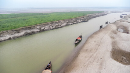 Brahmaputra river and boats in the winter, paddy field on the river's bank