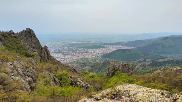 Panoramic view of the valley on top of the rocky ridge among the stones overlooking the beautiful valley. Outdoor and mountain hike background. Natural landscape in Bulgaria, Sliven