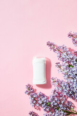 White antiperspirant deodorant with lilac branches on a pink background