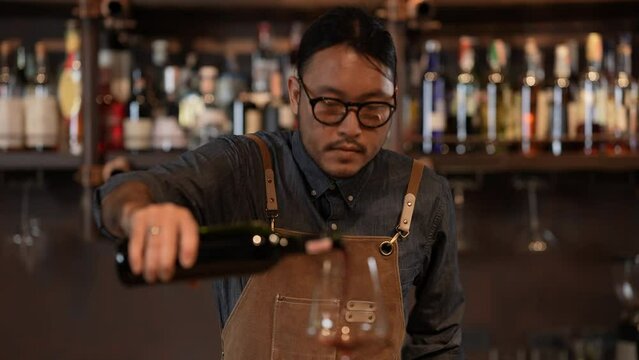 Night club concept of 4k Resolution. The bartender is confidently pouring wine into glasses. A group of specialized clubs that sell alcoholic beverages.