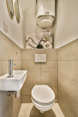 a toilet and sink in a bathroom with beige tiles on the wall behind it is a mirror above the toilet