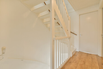 an empty room with wood flooring and white railings on the staircase leading up to the second floor in this house