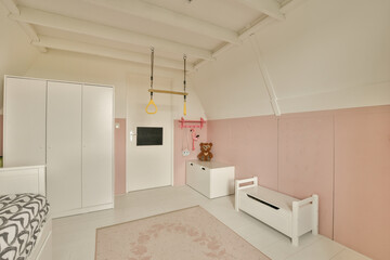 a girl's room with pink walls, white furniture and a teddy bear hanging on the wall in the corner