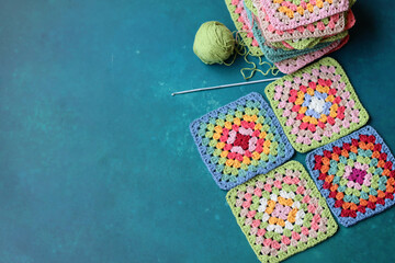 Crochet project in making. Colorful crochet squares close up photo. Hand made top in process. 