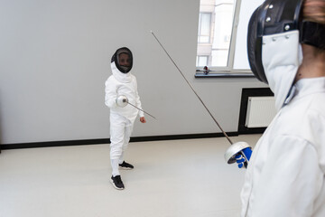 Fencer woman with fencing sword. Fencers duel concept.