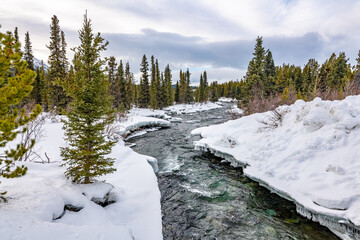 A winter wonderland seen in northern Canada, Yukon Territory during freezing cold season with deep snow along a wilderness river, creek.
