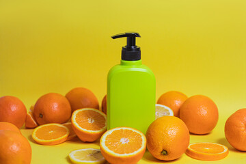 Bottle of cosmetic product with vitamin C and oranges on color background