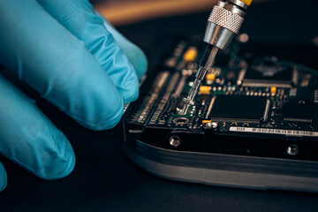 Computer service engineer technician workplace repairing fixing disassembled HDD hard drive data disc SSD, backup part of PC or laptop. Recovery, maintenance work, access file. Profession repairman
