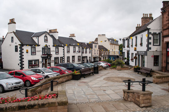 Melrose, Scotland - July 15, 2012: Main square in Melrose, UK with old white houses and flags as decoration.