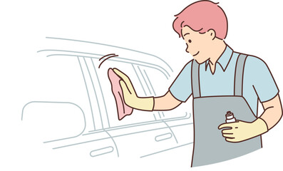 Man car wash employee polishes glass of sedan using special spray to add shine and repel water