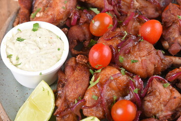 fried chicken with tomatoes and caramelized onions wings with herb sauce