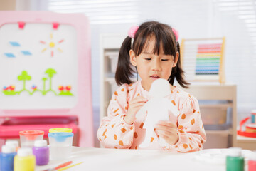 young girl was making colorful craft at home