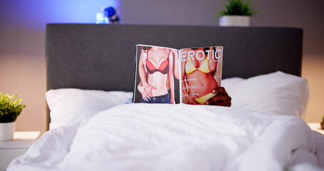 Man Lying On Bed Reading Erotic Magazine