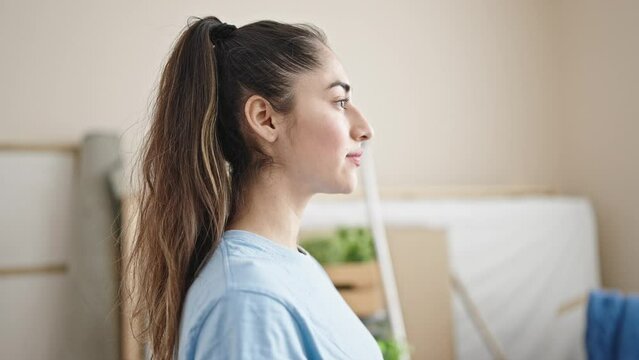 Young beautiful hispanic woman breathing with closed eyes at new home