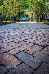 A very low angle photo on a cobblestone street facing a home in evening light.