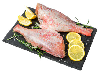 Fresh fish sebastes and ingredients for cooking. Raw gutted fish with spices and herbs on black slate isolated