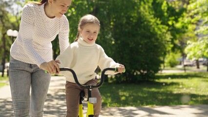 child learn ride bike. mother daughter girl park. happiness smile little child mom. dream family.,...