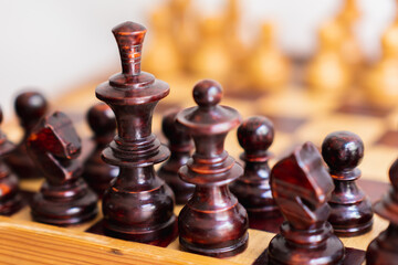 Detail photograph of dark chess pieces on top of game board, strategy game