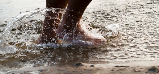 A man is running along the coast, training, legs and water closeup.