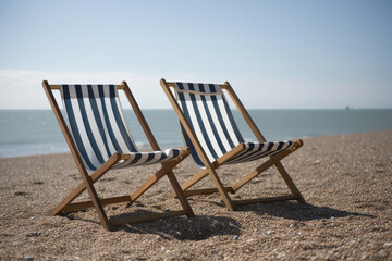 Fototapeta premium deckchairs on a beach, next to the sea, Created using generative AI tools.
