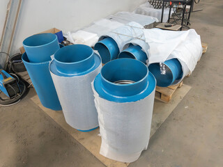 Blue flange expansion joints on the ground production area on the background of a concrete fence