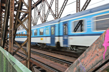 A passenger train passes over a railway bridge in Prague