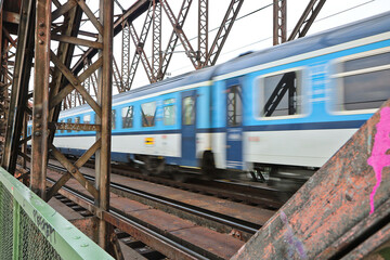 Naklejka premium A passenger train passes over a railway bridge in Prague