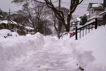 A snow filled residential street being shovelled out after a snow fall. Shot in the Toronto’s Beaches in February