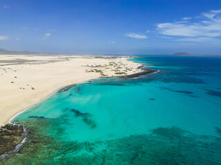 Beautiful high aspect aerial panoramic view of the white sandy beach of Playa del Dormidero near Corralejo in Fuerteventura Canary Islands Spain
